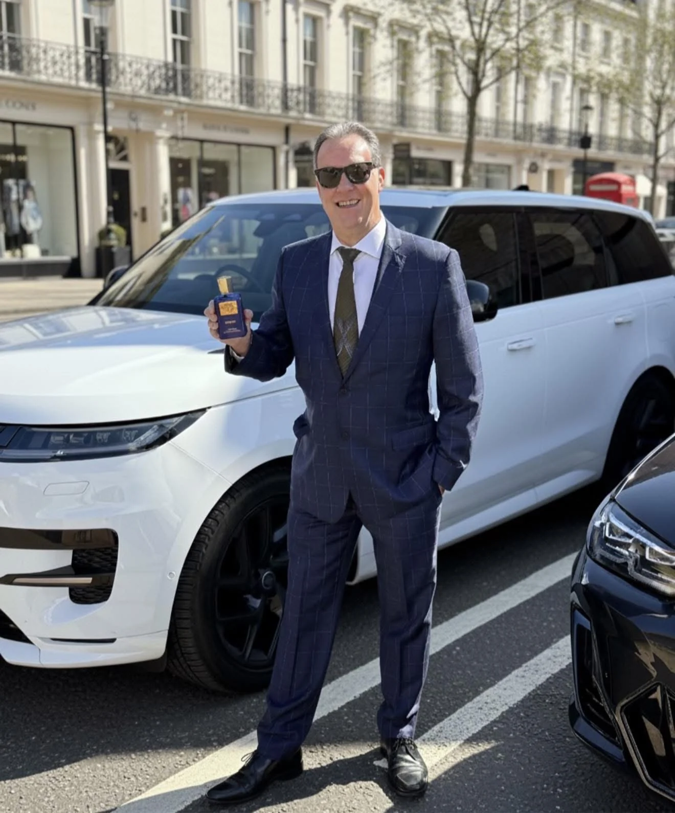 David Strickley, founder of ICON Partnership, photographed on a London street holding a Savile Row Private Collection fragrance