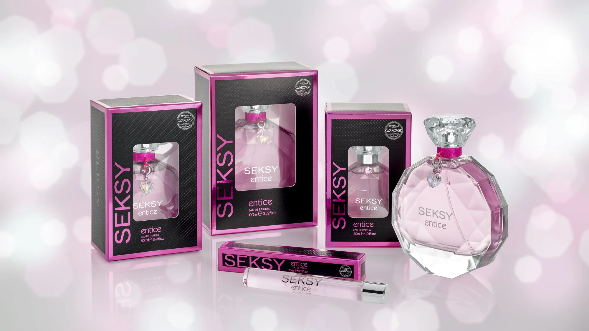Seksy Entice eau de parfum with its cartons and roll-on, photographed against a pink bokeh ground